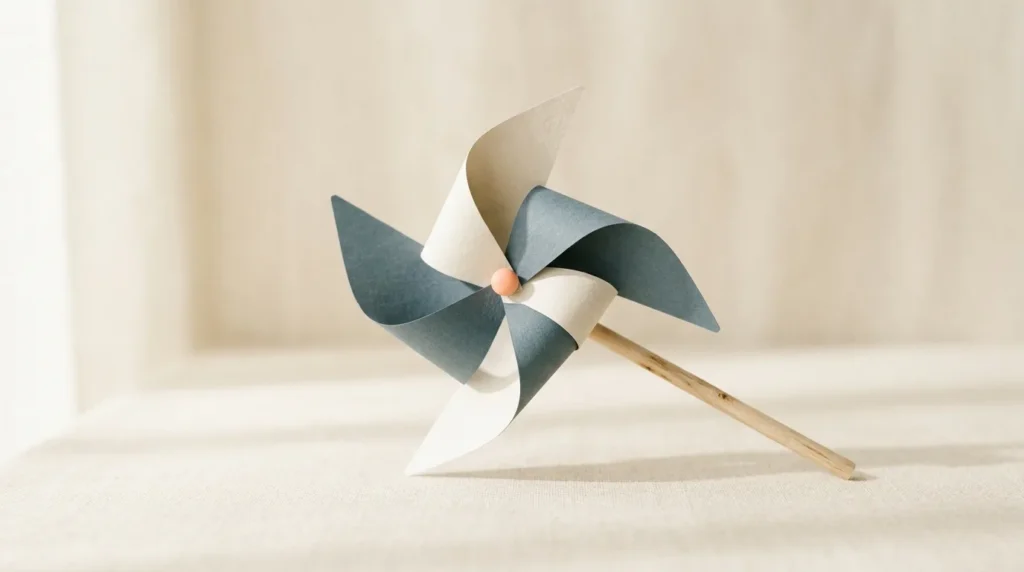 Paper pinwheel in slate and cream on a wooden stick